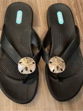 OKA b. Black Women's Flip Sandals with Gold Sand Dollar Accent